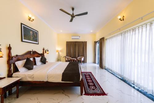 a bedroom with a large bed with a ceiling fan at Soma Jawai in Bijāpur