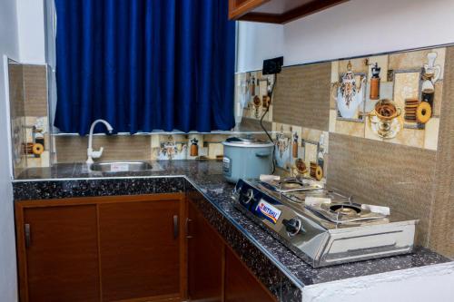 a kitchen counter with a stove and a sink at Malika homestay in Midigama East