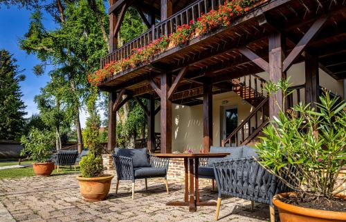 a patio with a table and chairs and plants at Hotel La Chaumiere in Dole