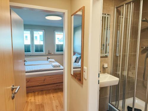 a bathroom with a bed and a sink and a mirror at Apartmenthaus Leuchtfeuer in Norderney