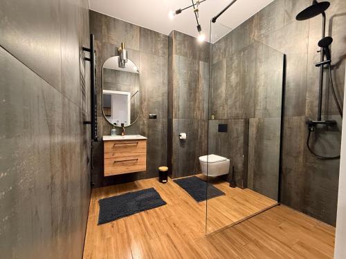 a bathroom with a sink and a toilet and a mirror at ZaciszeHouse in Noworąblów