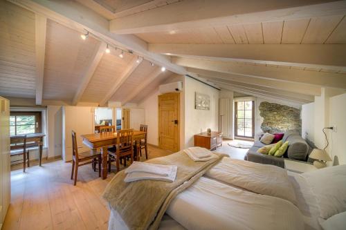 a bedroom with a large bed and a dining room at Casa Vacanza Nonna Pia I & III in "Piazza Basilica" in Tirano