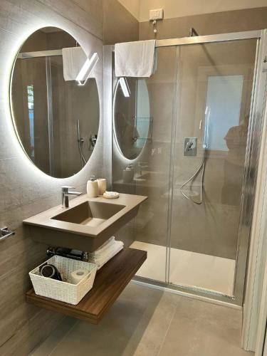a bathroom with a sink and a shower with a mirror at Anastasi Residence in Cervia