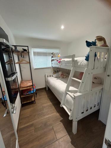 a room with two bunk beds and a ladder at Chalet K94 - Sunset View in Camber
