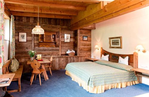 una camera da letto in una baita di tronchi con letto e scrivania di Rasmushof - Hotel Kitzbühel a Kitzbühel