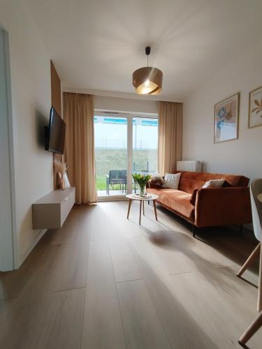 a living room with a couch and a table at Apartament MiA in Mrągowo