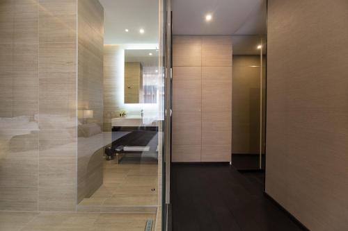 a bathroom with a glass door leading to a bedroom at Dominic Smart & Luxury Suites - Republic Square in Belgrade