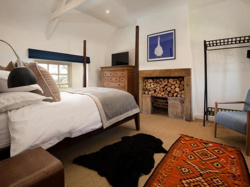 a bedroom with a large bed and a fireplace at The Old Coach House in Alnwick