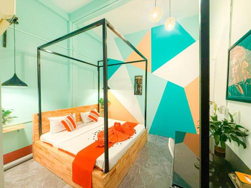 a bedroom with a bed and a colorful wall at Social Backpacker Hostel & Rooftop Bar in Battambang