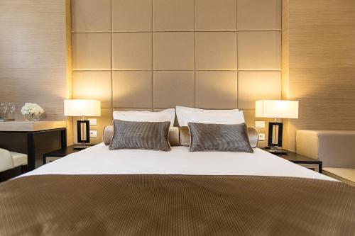 a bedroom with a large bed with two lamps at Dominic Smart & Luxury Suites - Republic Square in Belgrade