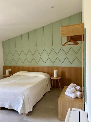a bedroom with a bed and a table with towels at Tarsis Guest House in Baunei