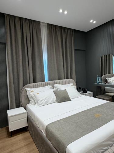 a bedroom with a large bed and a window at Hotel Monaco in Kamëz