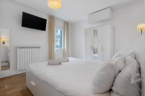 a white bed with white pillows in a bedroom at Venezia, 15 minutes from Venice, Parking,Shuttle airport, Train station Miranese in Mestre