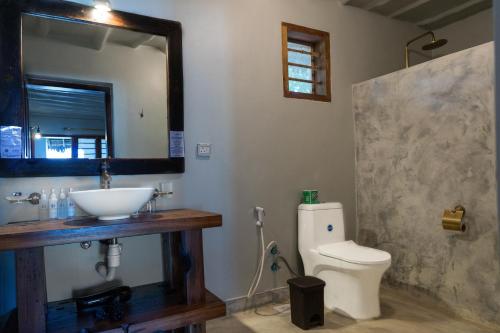 a bathroom with a sink and a toilet and a mirror at NDAME Paje Hotel in Paje