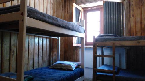 two bunk beds in a room with a window at Portezuelo del Viento - Hostel de Montaña in Las Cuevas
