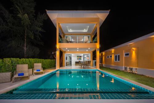 a house with a swimming pool at night at Sunset Emily Villas & Rooms in Ko Chang