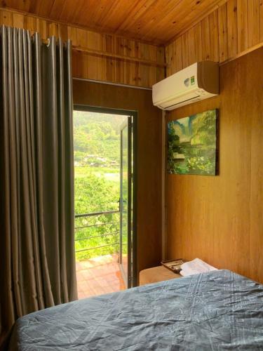 a bedroom with a bed and a window with a view at Moc's House bắc hà in Bắc Hà