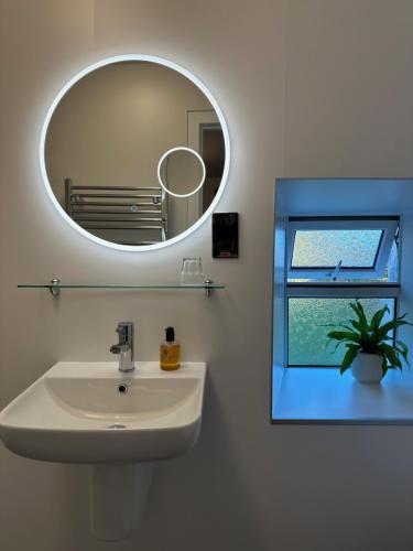 a bathroom with a white sink and a mirror at Roskhill House in Dunvegan