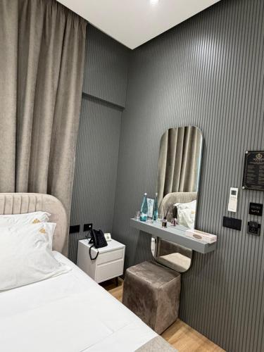 a bedroom with a bed and a mirror on the wall at Hotel Monaco in Kamëz