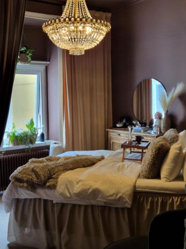 a bedroom with a large bed and a chandelier at Hotell Onyxen, boutique- & lifestyle, Adults Only in Gothenburg