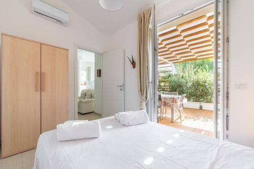 a white bedroom with a large bed and a balcony at Central Terrace, Pula in Pula