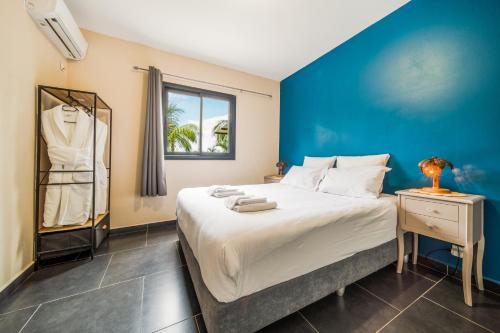 a bedroom with a large bed with a blue wall at La Mezina in Saint-Joseph