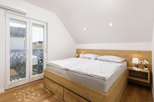 a bedroom with a bed and a large window at Vila Šenčur in Šenčur