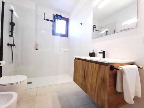 a white bathroom with a sink and a toilet at Domus Luna in Teulada
