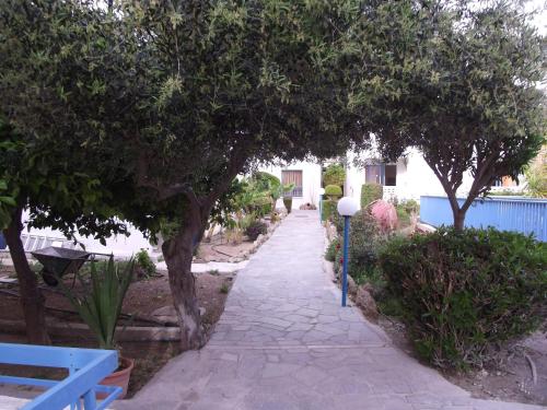 a stone walkway with trees and a street light at Kefalonitis Hotel Apartments in Paphos City