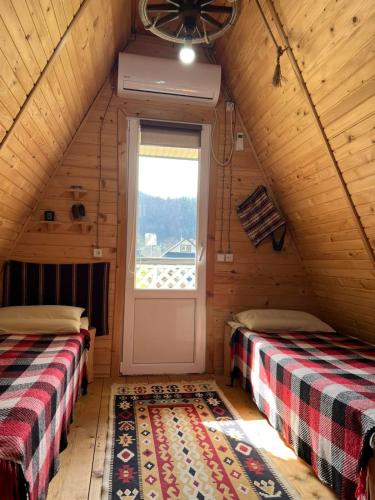 a room with two beds and a door in a cabin at Gesteruv in Sheshory