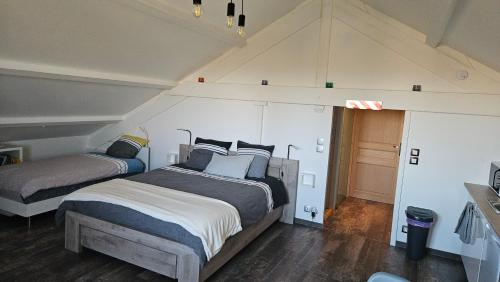 a bedroom with two beds in a attic at L'escale Aéro Lyon in Saint-Laurent-de-Mure