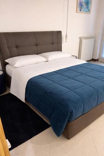 a large bed with a blue blanket on it at Boca Luxury Rooms in Tarquinia