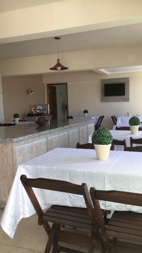 a dining room with tables and chairs and a kitchen at Open Hotel in Telêmaco Borba