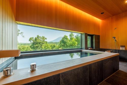 an indoor pool in a house with a large window at Hiyoku 飛翼 in Niseko