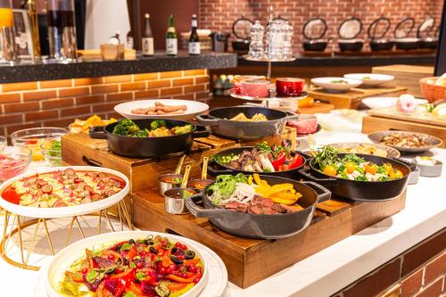 a buffet with many plates of food on a table at Hotel Keihan Kyoto Grande in Kyoto