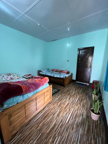 a bedroom with two beds and a blue wall at Jumusing homestay in Rupa