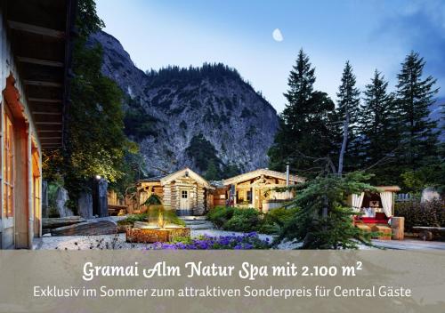 a picture of a house in front of a mountain at Hotel Central - das kleine Boutique Hotel am Achensee in Pertisau