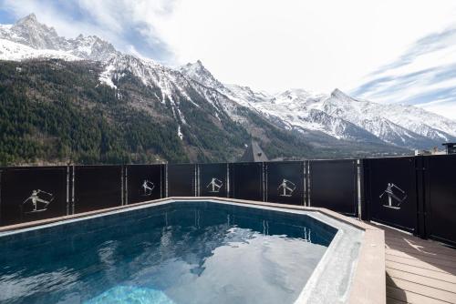 a swimming pool with mountains in the background at Park Hotel Suisse & Spa in Chamonix