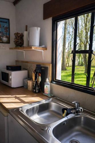 a kitchen counter with a sink and a window at Chez Elise et Joseph in Mons-Boubert