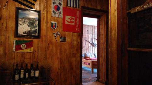 a room with a wooden wall with bottles of wine at Portezuelo del Viento - Hostel de Montaña in Las Cuevas