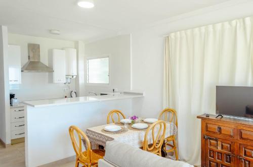a kitchen and dining room with a table and chairs at Apartamentos Cala Llevado in Tossa de Mar
