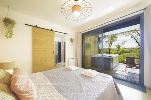 a bedroom with a bed and a sliding glass door at Les cabanes du Lac in Sévignac-Thèze
