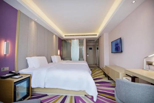 a bedroom with a large white bed and a desk at Lavande Hotel Xi'an Bell Tower in Xi'an
