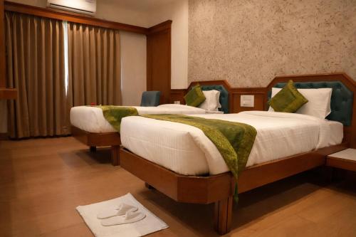 a hotel room with two beds in a room at The Indies 365 Hotel in Bangalore