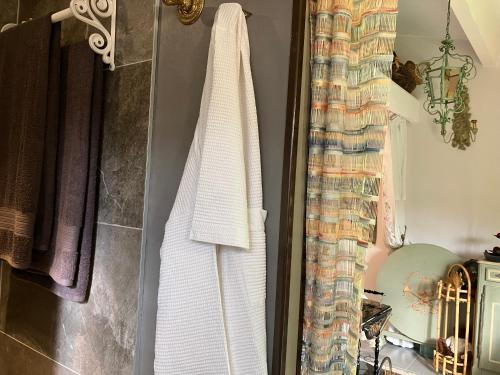 a white towel hanging on a wall in a bathroom at Une amazone en Provence in Paradou