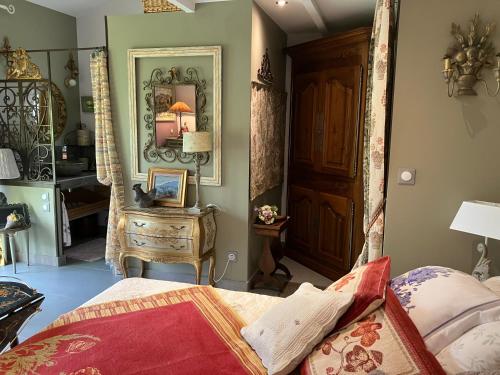 a bedroom with a bed and a mirror and a dresser at Une amazone en Provence in Paradou