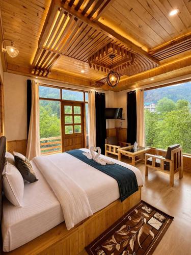 a bedroom with a large bed and a large window at Mountain Route Cottage in Manāli