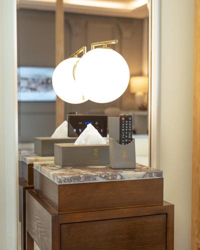 a lamp on top of a dresser in a room at The Nishat Hotel Johar Town in Lahore