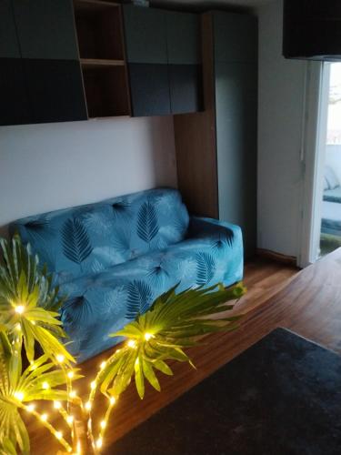 a blue couch sitting in a living room with lights at Grand studio cosy et lumineux in La Rochelle