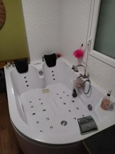 a white bath tub with a sink in a bathroom at Grand studio cosy et lumineux in La Rochelle
